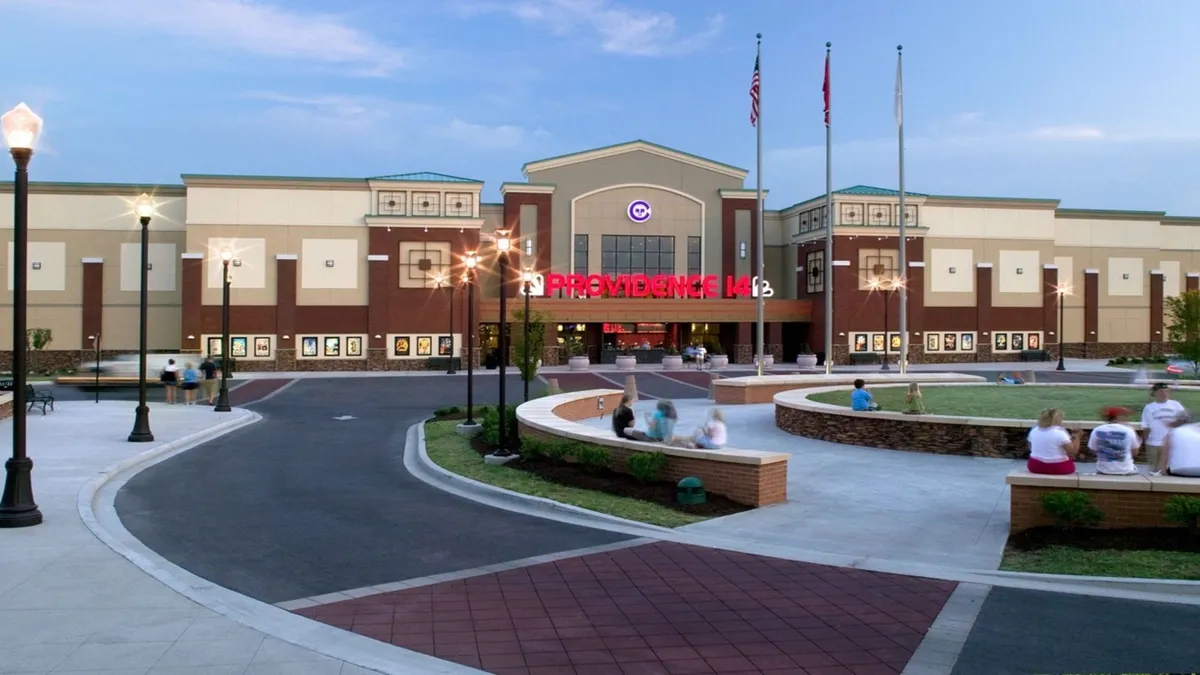 An exterior shot of the Providence theater entrance, with its prominent sign and landscaped pathways, creating a sense of local excitement and social vibrancy. The image captures a communal atmosphere, inviting guests to experience the neighborhood's entertainment and dining options.